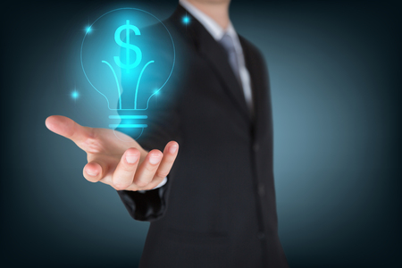 Businessman holding the glowing dollar bulb as business, innovation, intelligent, idea, income and investment conceptの写真素材