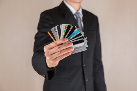 BANGKOK, THAILAND OCTOBER - 14 2017: Close up of businessman holding the many credit and debit card before buying product.のeditorial素材