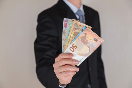 Businessman hold United Arab Emirates Dirham (AED) money as business, trade, investment and income...