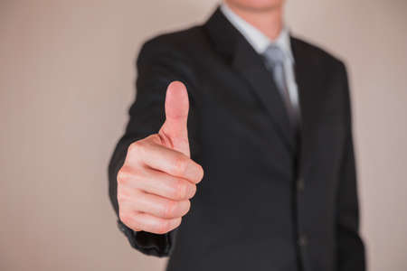 Businessman give a thumbs up for compliment as business, praise, congratulate, good and like concept.の写真素材