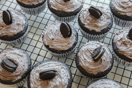 Homemade dark chocolate cupcakes with cookie and cream frostingの写真素材