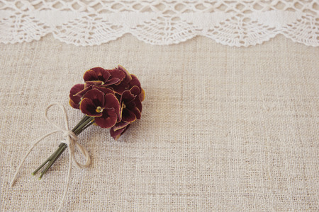 Red flowers on linen and lace, copy space background, selective focus, vintage tone
