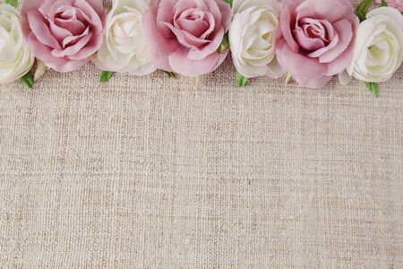 Artificial pink white rose flowers on linen, copy space background, selective focus, vintage toneの写真素材