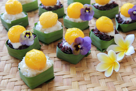 Homemade coconut sticky rice with mango in pandan leaves cup, selective focusの写真素材