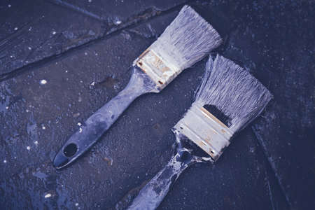 Used paintbrushes on black patio floor, soft selective focus, toningの写真素材