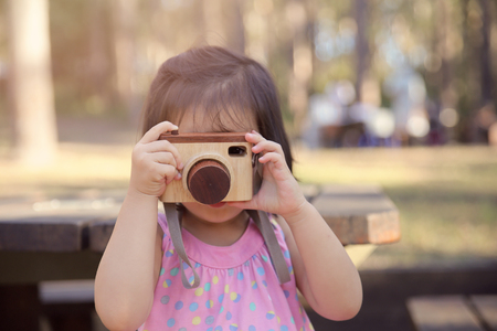 a girl holding toy camera in the park, selective focus, toningの写真素材