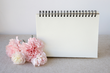 Notepad with pink flowers mock up, selective focusの写真素材