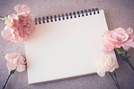 Notepad with pink flowers mock up, selective focus, toningの写真素材