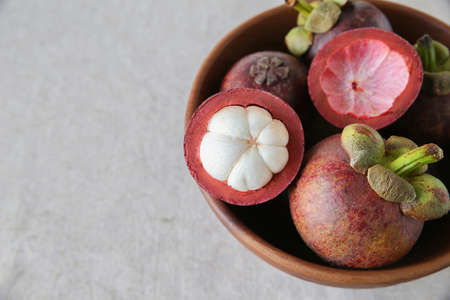 Mangsteen in wooden fruit bowl, copy space backgroundの写真素材