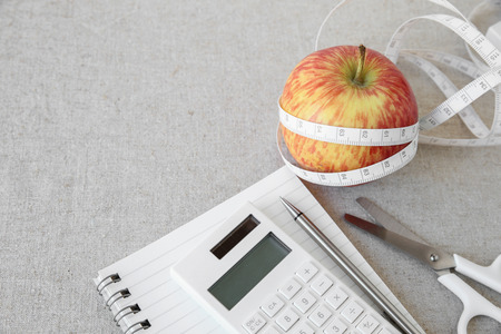 Apple, tape measure, notebook and calculator background for diet plan, weightloss planの写真素材