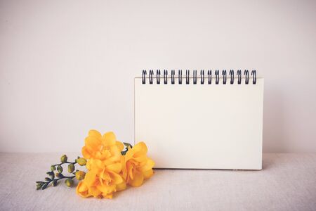 Notepad with yellow flowers mock up,  toningの写真素材