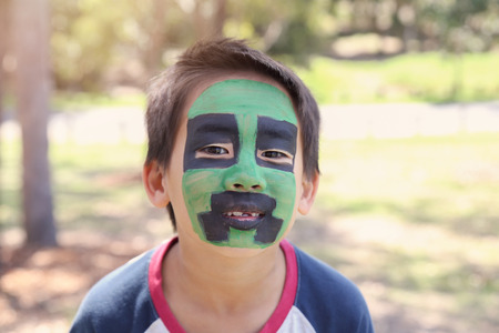 Young boy with fun green and black face painting