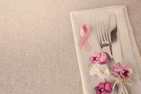 Pink ribbon day table setting with pink flowers, copy space toning backgroundの写真素材