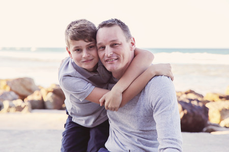 Father and son hugging on the beach, toningの写真素材