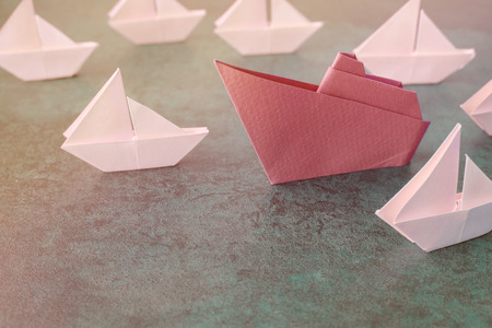 Origami paper ship with small sailboats, female woman leadership business concept, toningの写真素材