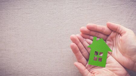 hands holding green paper house, eco house conceptの写真素材