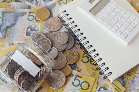 Australian money in glass jar, AUD with calculator, notebook, saving conceptの写真素材