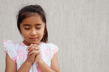 multicultural hispanic girl child praying with eyes closed, christianity faith conceptの写真素材