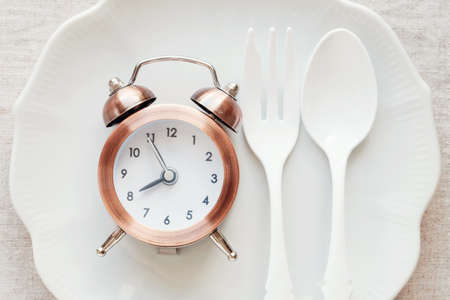 A clock on the plate, Intermittent fasting diet conceptの写真素材