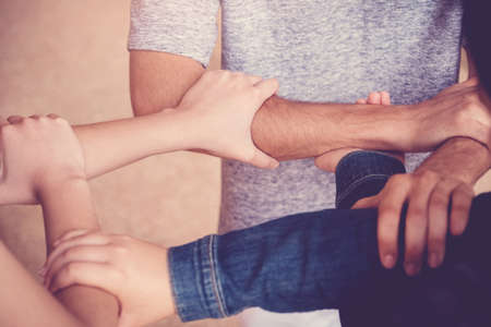 Multiethnic hands of young adults putting hands together, volunteer and charity teamwork, all lives matter conceptの写真素材