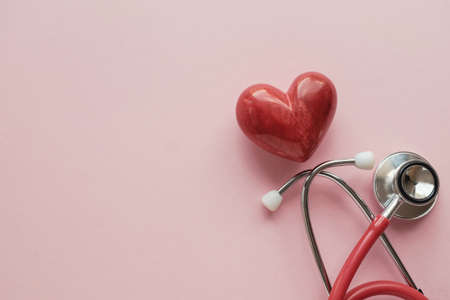 Red heart with stethoscope on pink background, heart health,  health insurance concept, World heart day, world health dayの写真素材