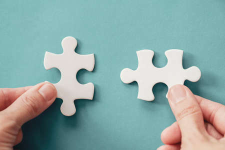 Hands with jigsaw puzzle pieces, Business strategy planning, Alzheimer's disease, Autism and mental...