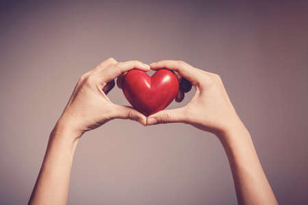 Woman holding red heart, health insurance, donation, happy charity volunteer concept, world mental health day, world heart dayの写真素材