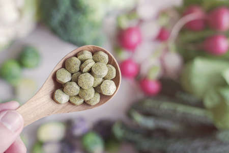 Cruciferous vegetables tablets in wooden spoon, dietary fiber prebiotic supplements for healthy gutの写真素材