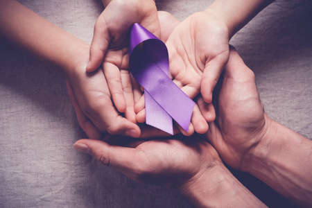 Adult and child hands holding purple ribbons, Alzheimer's disease, Pancreatic cancer, Epilepsy awareness, world cancer dayの写真素材