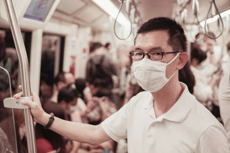 Middle aged Asian man wearing glasses and medical face mask,  Wuhan coronavirus outbreak, air pollution and health conceptの写真素材