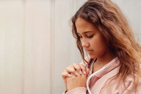 multicultural teen girl, youth teenager praying with eyes closed, christianity faith conceptの写真素材