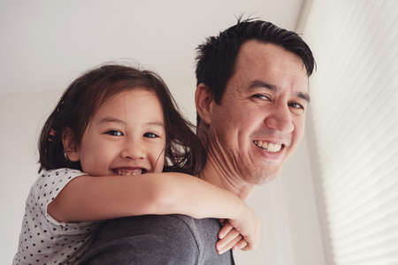 Happy multicultural Asian daughter with her father at homeの写真素材