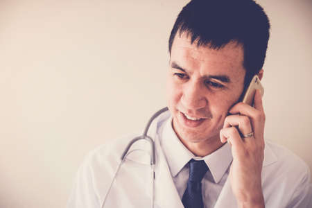 Mixed race medical male doctor on the phone, working remotely, telehealth, distance consulting conceptの写真素材