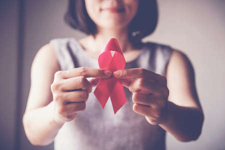 Asian woman holding pink ribbon, breast cancer awareness, October pink conceptの写真素材
