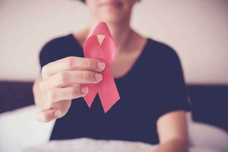 middle age woman holding pink ribbon, breast cancer awareness, October pink conceptの写真素材