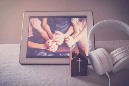 Children praying with father parent with laptop, family and kids worship online together at home, streaming online church service, social distancing conceptの写真素材