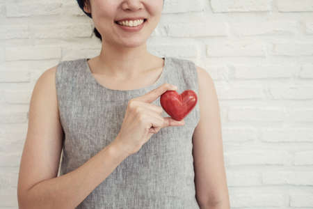 Asian woman holding red heart, health insurance, donation charity conceptの写真素材