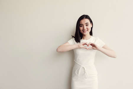 young woman making her hands in heart shape, heart health insurance, social responsibility, donation charity, world heart day, appreciation, all lives matter, no to racism conceptの写真素材