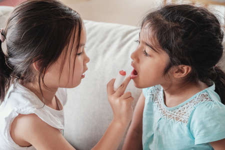 young multicultural kids doing make up pretend playの写真素材