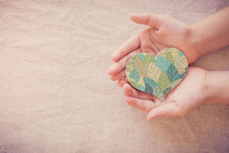 Hands holding leaf heart shape, CSR social responsibility, eco sustainable living, vegan, world environment day, Earth Dayの写真素材