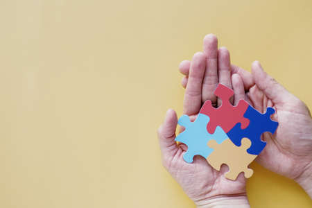 Hands holding puzzle jigsaw,  mental health concept, world autism awareness day