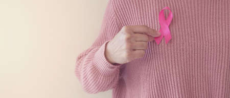 woman hand holding pink ribbon, breast cancer awareness, October pink, World cancer day conceptの写真素材