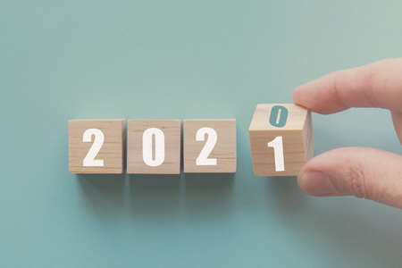 Hand flipping over wooden block of 2020 to 2021, New Year Resolutions, business conceptの写真素材