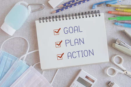 2021 New year resolution, Goal, Plan and action on notepad and stationery supplies, medical masks and hand gel sanitizerの写真素材