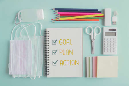2021 New year resolution, Goal, Plan and action on notepad and stationery supplies, medical masks and hand gel sanitizerの写真素材