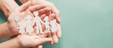 Adult and children hands holding paper family cutout, family home, adoption, foster care, homeless support, family mental health conceptの写真素材
