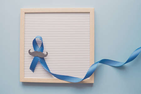 Blue ribbon with mustache  on letter board, Prostate Cancer Awareness, Men health awarenessの写真素材