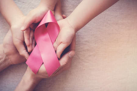 hands holding pink ribbon, breast cancer awareness, October pink conceptの写真素材