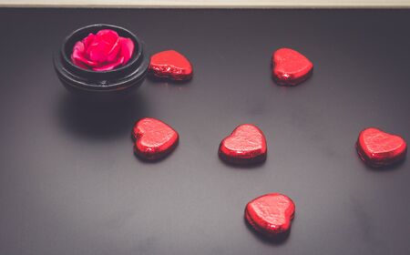red heart chocolate and rose on blackboard in dark.の写真素材