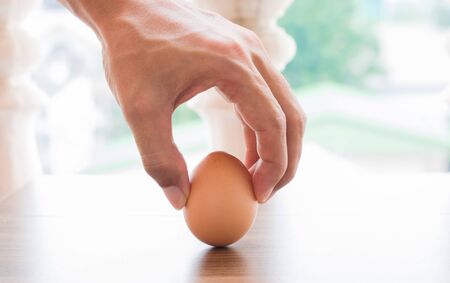 hand man holding egg.